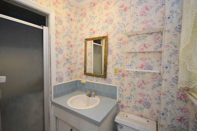 bathroom with ornamental molding, vanity, a shower with shower door, and toilet