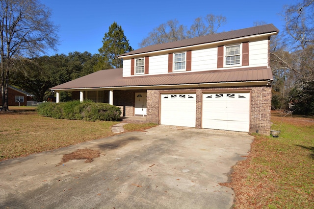 view of front of house featuring covered porch, a garage, and a front lawn