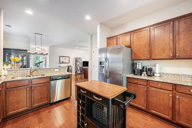 1723 Indaba Way, Charleston, SC 29414 - kitchen with stainless steel appliances, a sink, light wood-style floors, brown cabinets, and recessed lighting