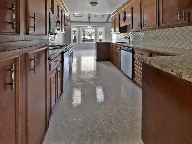 kitchen featuring light stone countertops, appliances with stainless steel finishes, sink, pendant lighting, and backsplash