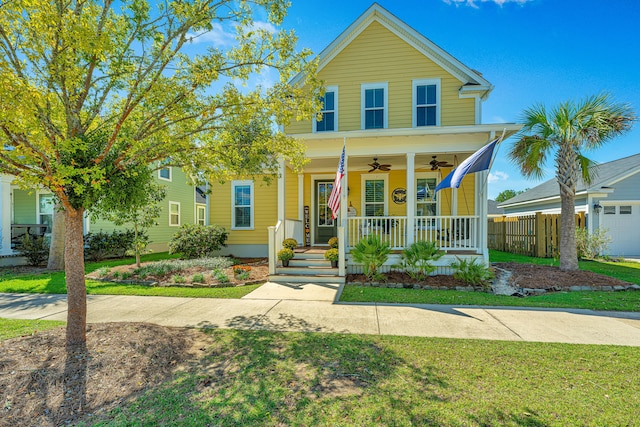 view of front facade featuring ceiling fan, a garage, a front lawn, and covered porch