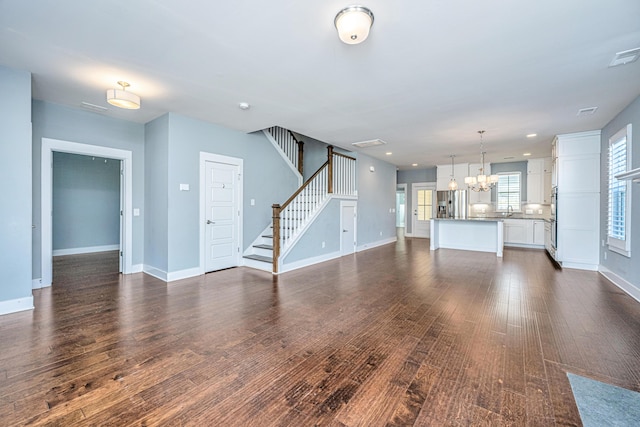 415 Watergrass Way, Summerville, SC 29485 - unfurnished living room with baseboards, a chandelier, dark wood finished floors, recessed lighting, and stairs