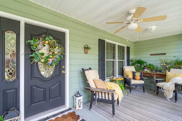 wooden deck featuring covered porch and ceiling fan