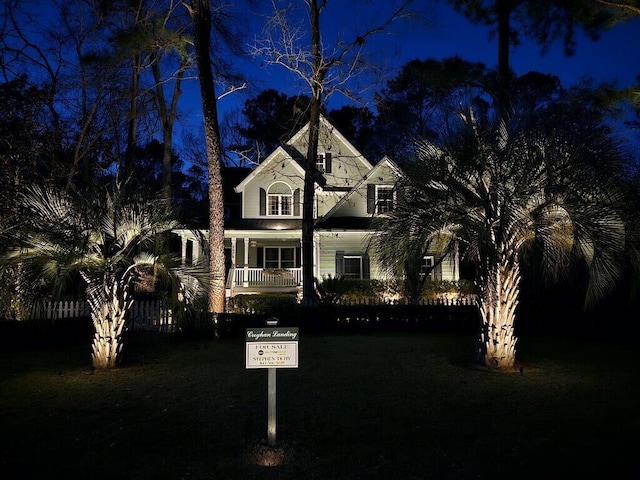 view of front of house featuring covered porch and a yard