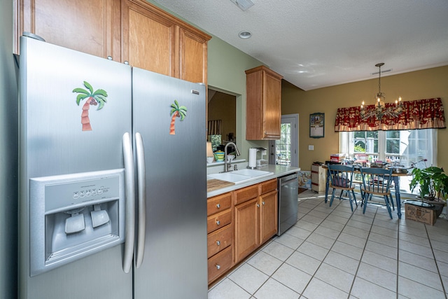 105 Northpark Ave, Summerville, SC 29485 - kitchen featuring stainless steel appliances, a sink, light countertops, light tile patterned floors, and brown cabinetry