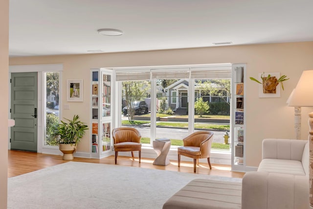 sitting room featuring wood finished floors, visible vents, and baseboards