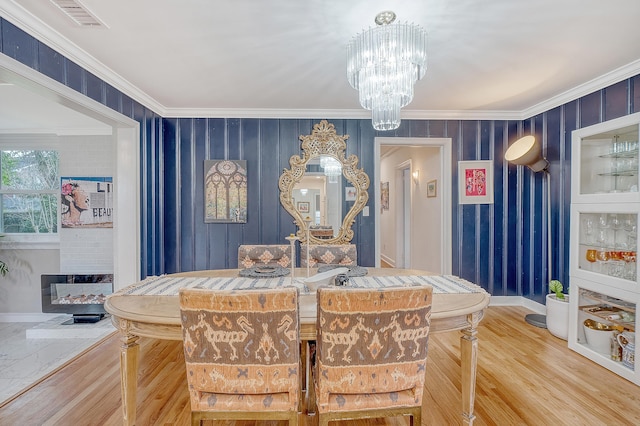 dining room with visible vents, ornamental molding, wood finished floors, a chandelier, and baseboards