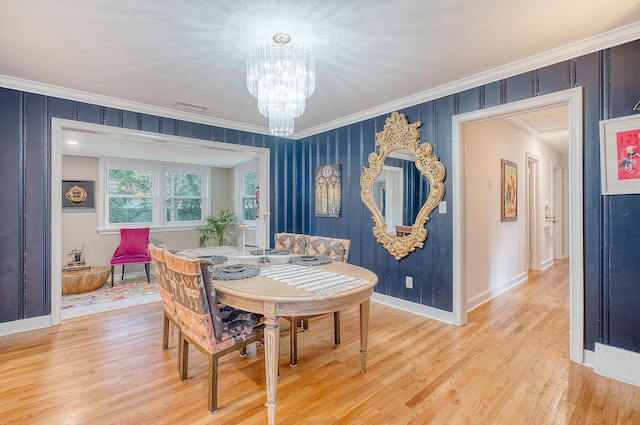 dining area featuring light wood-style flooring, visible vents, crown molding, and a notable chandelier