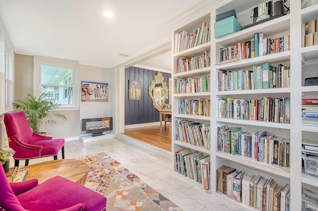 sitting room featuring ornamental molding, marble finish floor, and baseboards