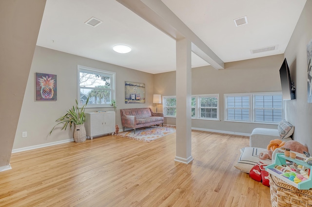 sitting room featuring beam ceiling, baseboards, visible vents, and light wood finished floors