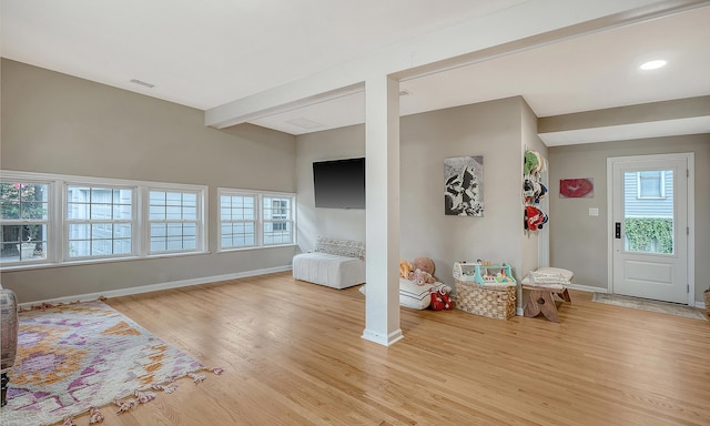 interior space with baseboards, light wood finished floors, visible vents, and a healthy amount of sunlight