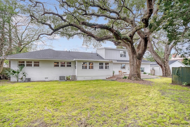 back of property with central AC unit, fence, roof with shingles, crawl space, and a lawn