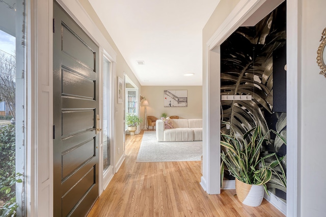 foyer entrance featuring light wood finished floors and baseboards