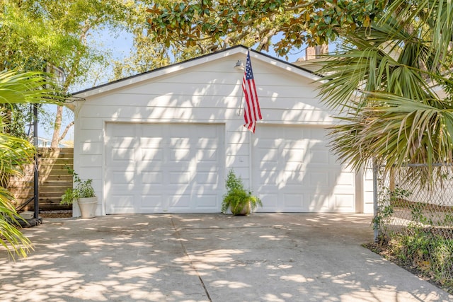 detached garage featuring fence