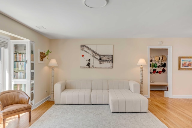 living room featuring a wealth of natural light, baseboards, and wood finished floors