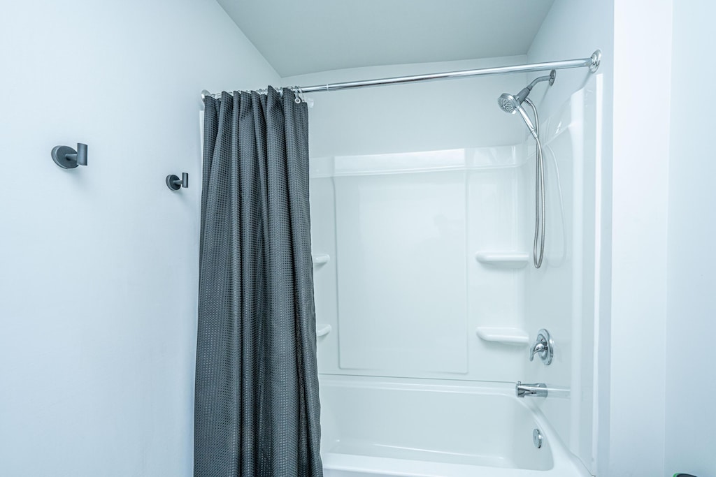 bathroom with shower / bath combo with shower curtain