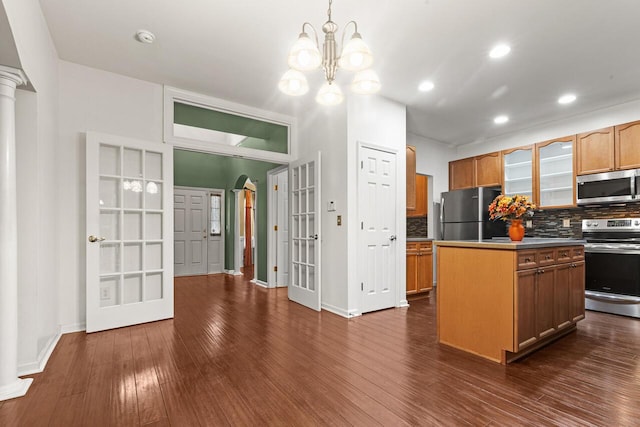 5404 Red Fork Ln, North Charleston, SC 29420 - kitchen with appliances with stainless steel finishes, decorative backsplash, dark wood-type flooring, baseboards, and a kitchen island