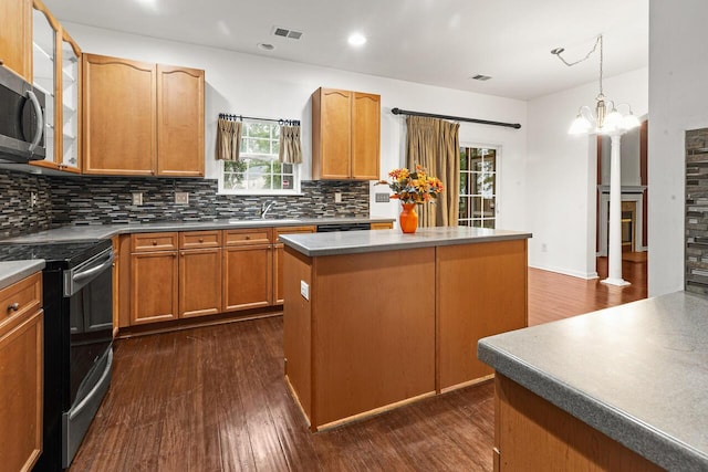 5404 Red Fork Ln, North Charleston, SC 29420 - kitchen featuring black range with electric cooktop, stainless steel microwave, backsplash, a center island, and a sink