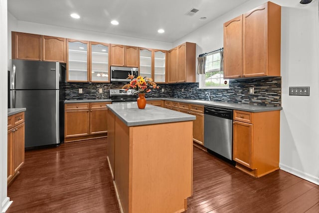 5404 Red Fork Ln, North Charleston, SC 29420 - kitchen featuring appliances with stainless steel finishes, dark wood-style flooring, a center island, backsplash, and a sink