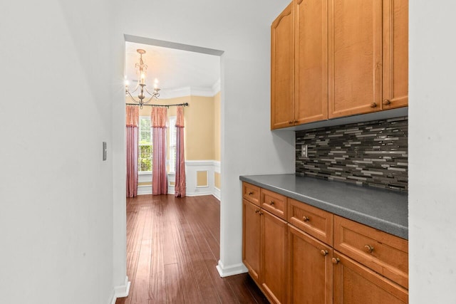 5404 Red Fork Ln, North Charleston, SC 29420 - bar featuring a chandelier, backsplash, dark wood-type flooring, ornamental molding, and a wainscoted wall