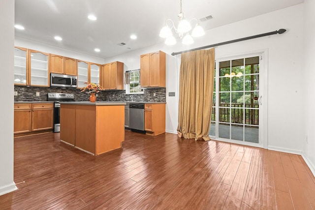 5404 Red Fork Ln, North Charleston, SC 29420 - kitchen featuring appliances with stainless steel finishes, a chandelier, decorative backsplash, a center island, and glass insert cabinets