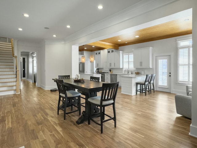 dining space with stairway, recessed lighting, light wood-type flooring, and ornamental molding