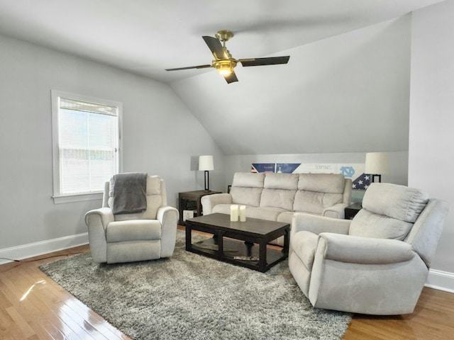 living area featuring vaulted ceiling, baseboards, ceiling fan, and wood finished floors