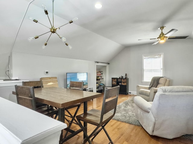 dining room with a ceiling fan, lofted ceiling, and light wood-style floors