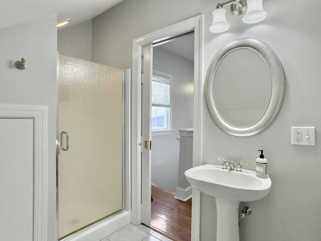 bathroom featuring tile patterned floors, a shower stall, and a sink