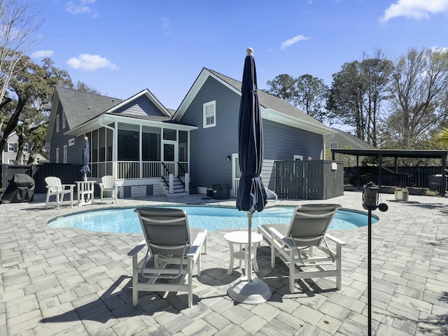 view of pool featuring a patio, fence, a fenced in pool, and a sunroom