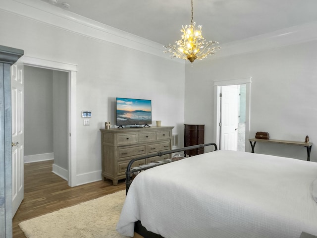 bedroom with ornamental molding, baseboards, an inviting chandelier, and wood finished floors