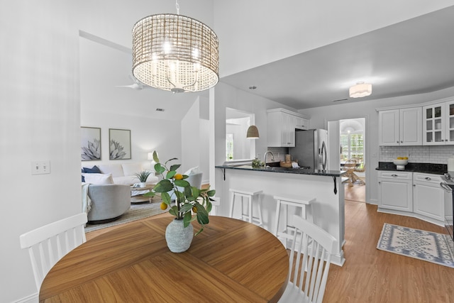 1441 Waterside Ct, Mount Pleasant, SC 29464 - dining area featuring light wood-style flooring, a chandelier, and a towering ceiling