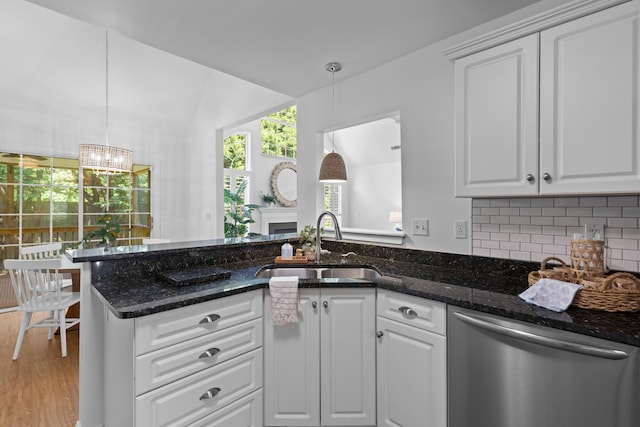 1441 Waterside Ct, Mount Pleasant, SC 29464 - kitchen featuring stainless steel dishwasher, white cabinets, a chandelier, light wood finished floors, and backsplash