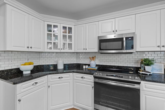 1441 Waterside Ct, Mount Pleasant, SC 29464 - kitchen featuring appliances with stainless steel finishes, white cabinetry, glass insert cabinets, and decorative backsplash