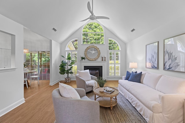 1441 Waterside Ct, Mount Pleasant, SC 29464 - living room featuring healthy amount of natural light, a ceiling fan, vaulted ceiling, wood finished floors, and a glass covered fireplace