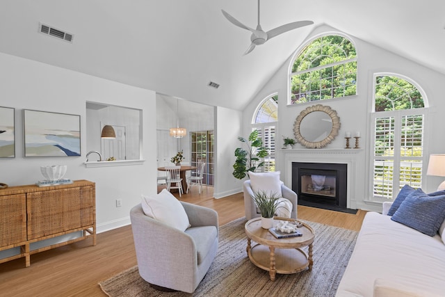 1441 Waterside Ct, Mount Pleasant, SC 29464 - living area with a ceiling fan, a glass covered fireplace, wood finished floors, and high vaulted ceiling