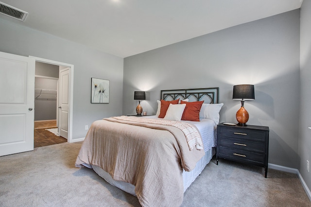 bedroom featuring a spacious closet, carpet floors, and a closet