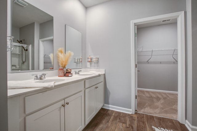 bathroom featuring walk in shower, vanity, and hardwood / wood-style floors