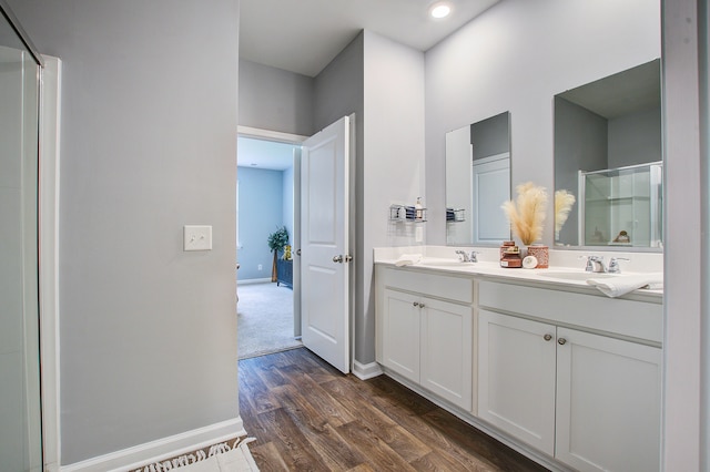 bathroom with vanity, hardwood / wood-style floors, and a shower with door