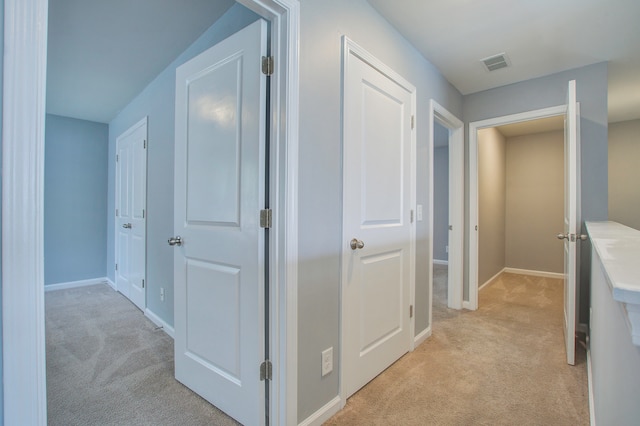 hall with light colored carpet