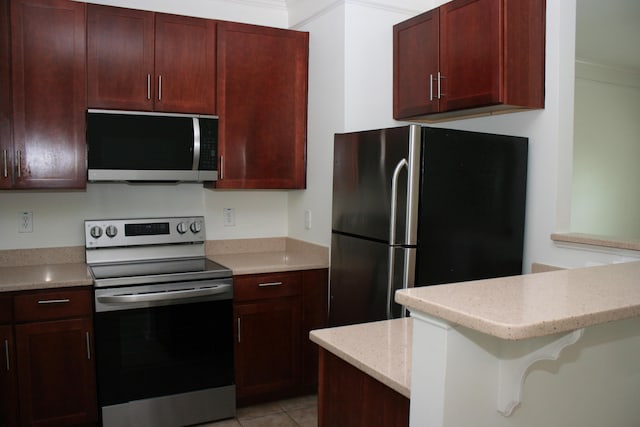 1755 Central Park Rd Unit 9103, Charleston, SC 29412 - kitchen featuring appliances with stainless steel finishes, dark brown cabinets, light tile patterned floors, and light stone counters