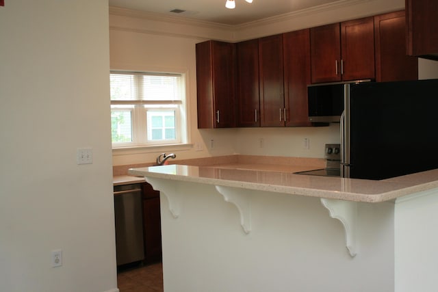 1755 Central Park Rd Unit 9103, Charleston, SC 29412 - kitchen with appliances with stainless steel finishes, a breakfast bar, light countertops, crown molding, and a peninsula
