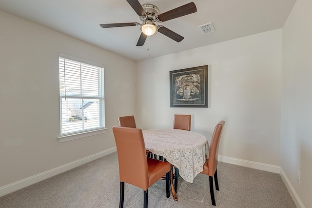 dining room with light colored carpet and ceiling fan