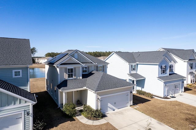 view of front of house with a garage, solar panels, and a front lawn