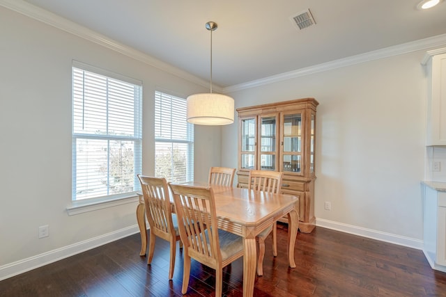 dining area with ornamental molding and dark hardwood / wood-style floors