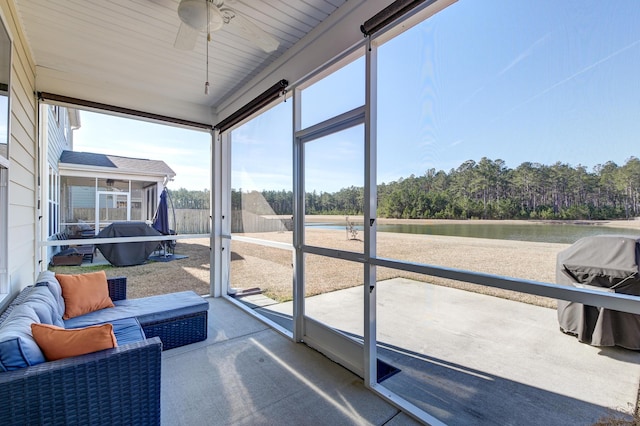 sunroom / solarium featuring a water view and ceiling fan