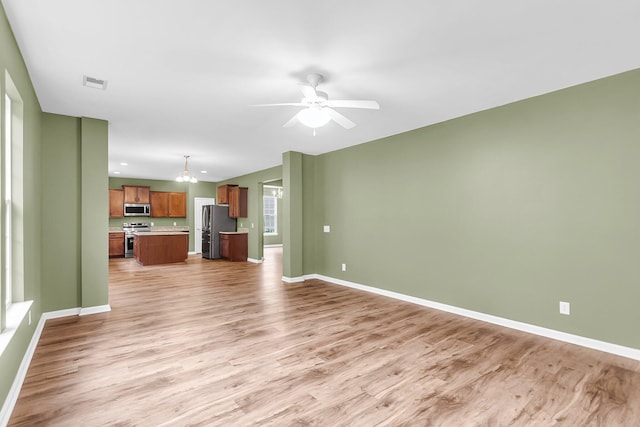 127 Rawlins Dr, Summerville, SC 29485 - unfurnished living room featuring light wood-type flooring, a chandelier, and a ceiling fan