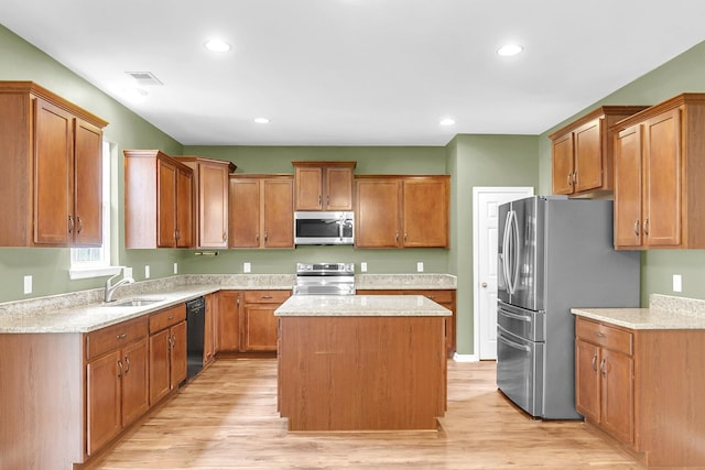 127 Rawlins Dr, Summerville, SC 29485 - kitchen featuring stainless steel appliances, a center island, brown cabinets, light wood-style floors, and light stone countertops