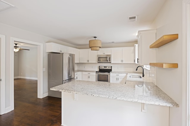 1506 Southwick Dr, Johns Island, SC 29455 - kitchen featuring stainless steel appliances, open shelves, a sink, a peninsula, and backsplash