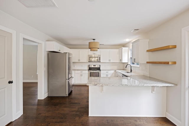 1506 Southwick Dr, Johns Island, SC 29455 - kitchen with appliances with stainless steel finishes, a sink, a peninsula, open shelves, and light stone counters